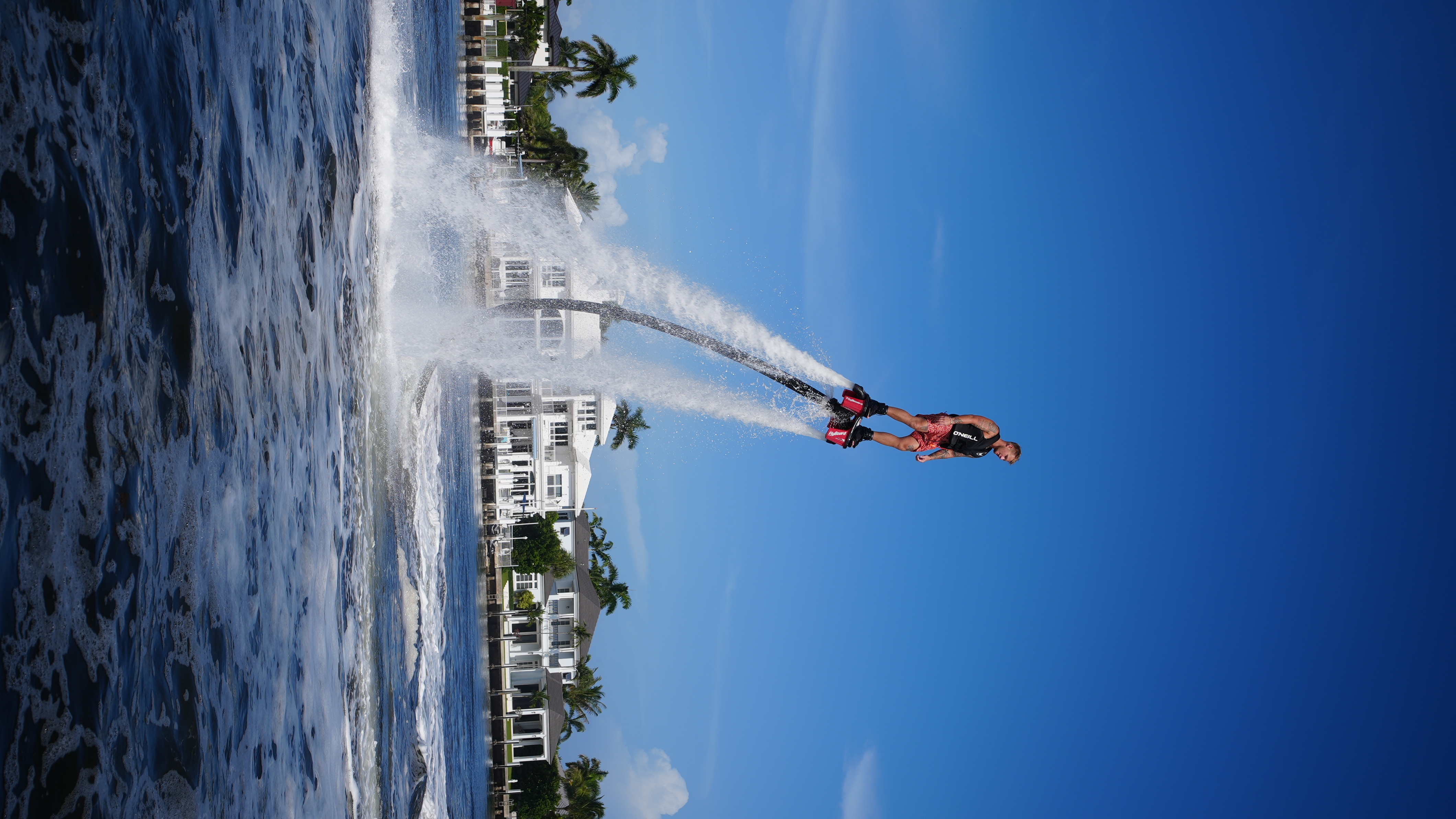 Flyboard rider lifted above the water by twin water jets